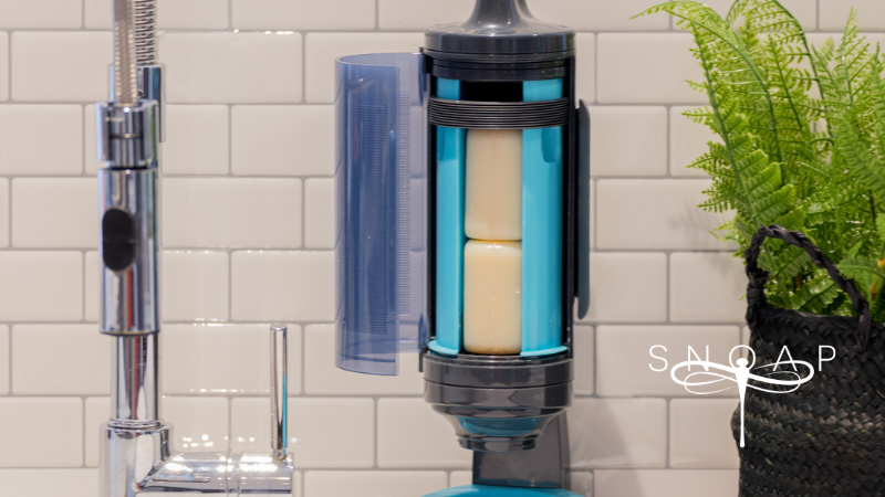 Refillable SNOAP soap dispenser mounted in a minimalist bathroom as part of sustainable living tips for beginners.