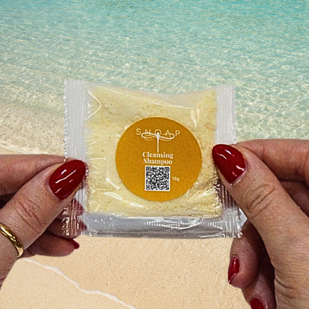 Cleansing Sweet Orange and Sandalwood SNOAP shampoo sample for greasy and oily hair on beach background