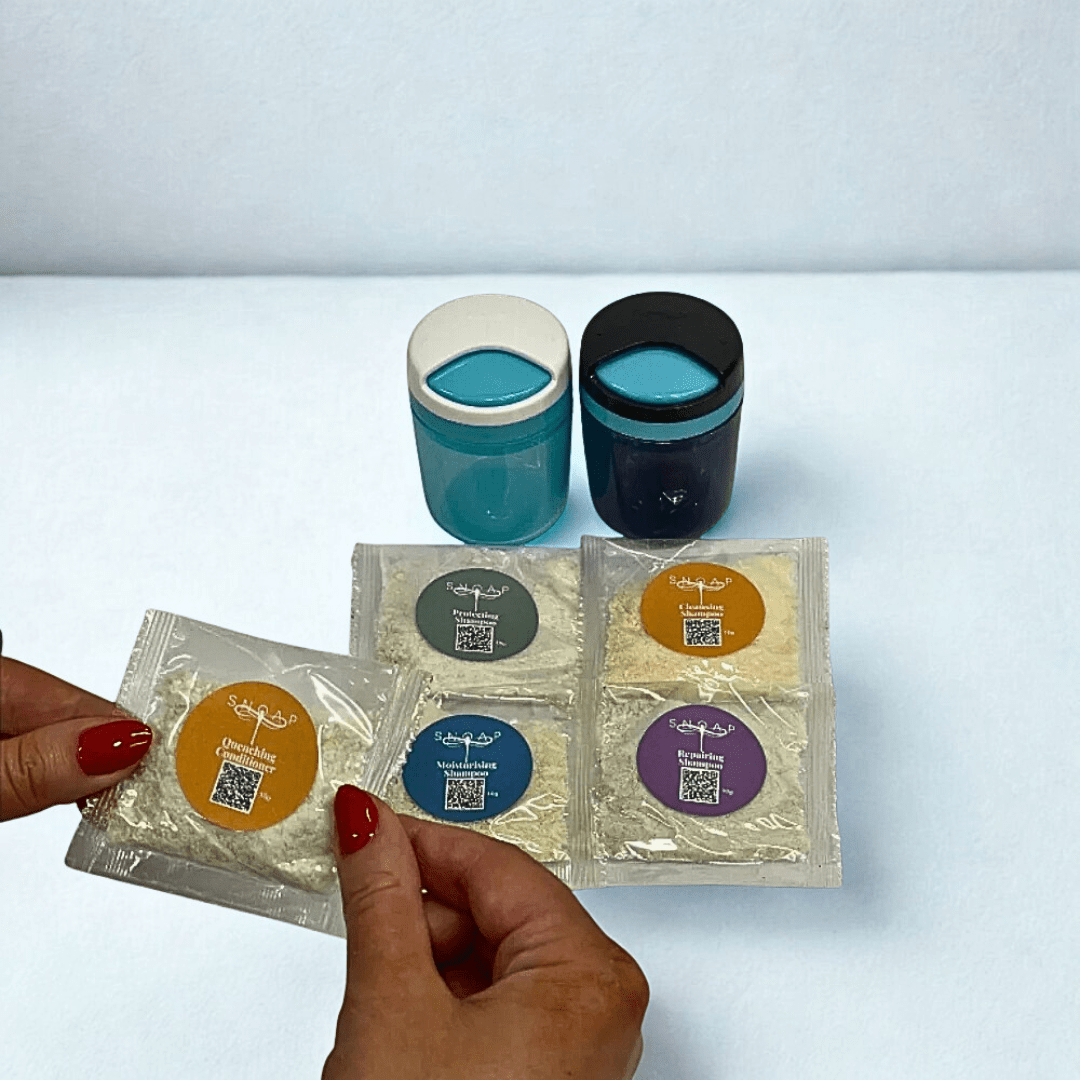 SNOAP hair care sampler products displayed on white background including 4 shampoos, one conditioner and 2 on-the-go dispensers to dispense them from