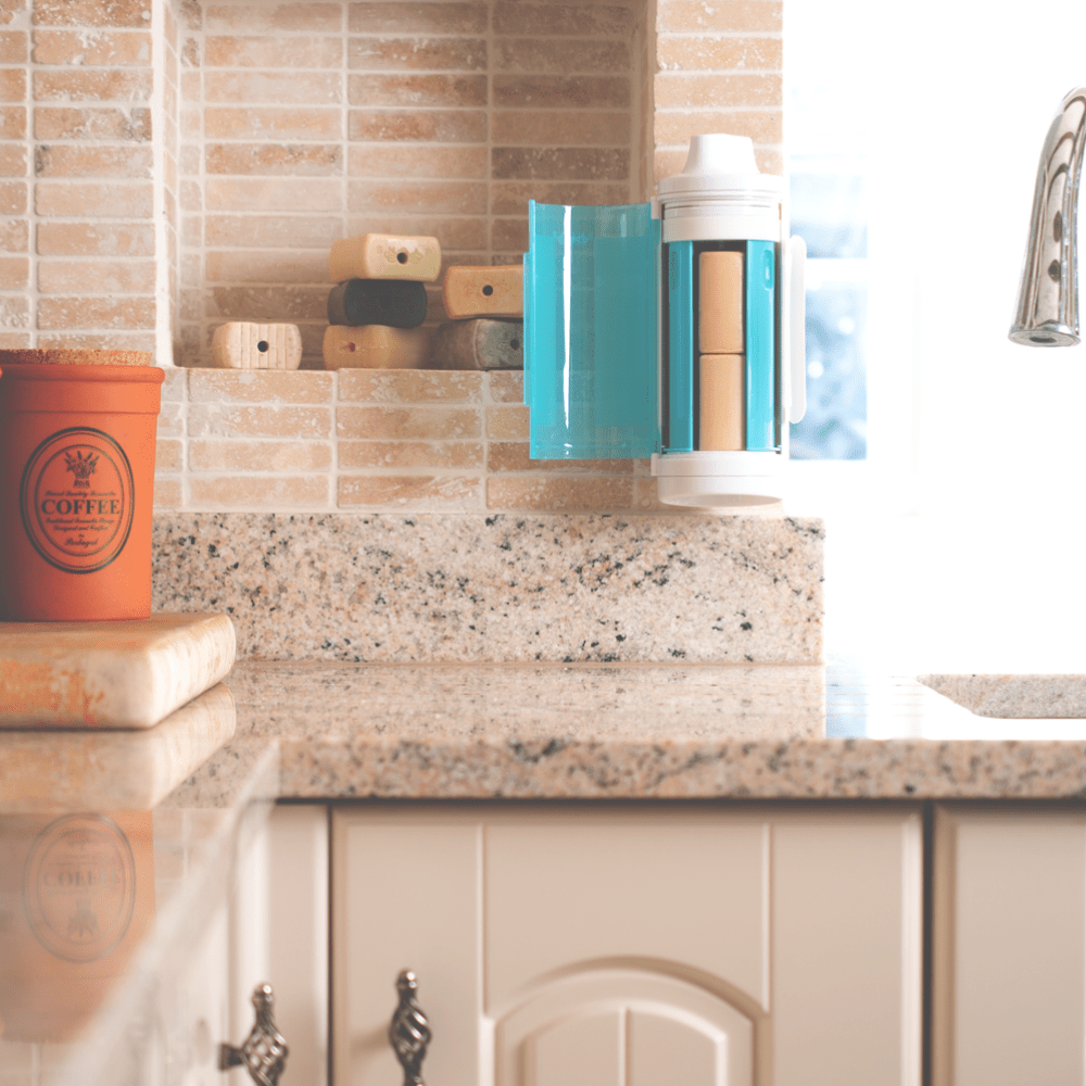 SNOAP Dispenser in white & SNOAP Blue Wall mounted in kitchen with door open showing 2 soap bars inside