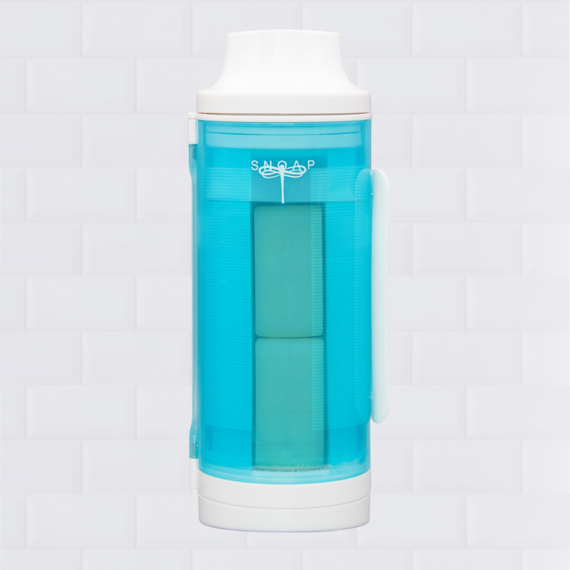 A wall-mounted SNOAP soap dispenser in white and SNOAP blue with a transparent section showing the internal mechanism.