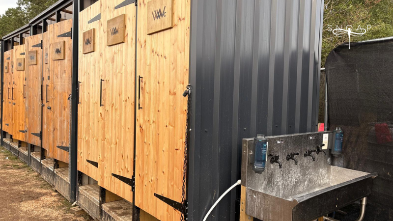 SNOAP Refillable Soap Dispenser System installed at an outdoor handwashing station beside Wild Willy Cabins compost toilets at Shambala Festival.